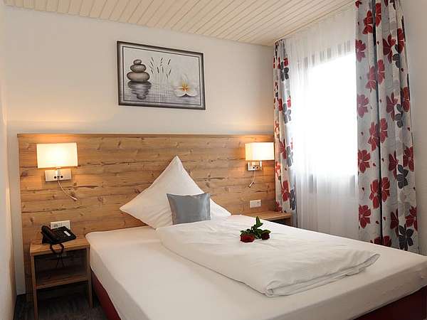 Freundlich eingerichtetes Zimmer mit Bett und Fenster im Hotel Lamm